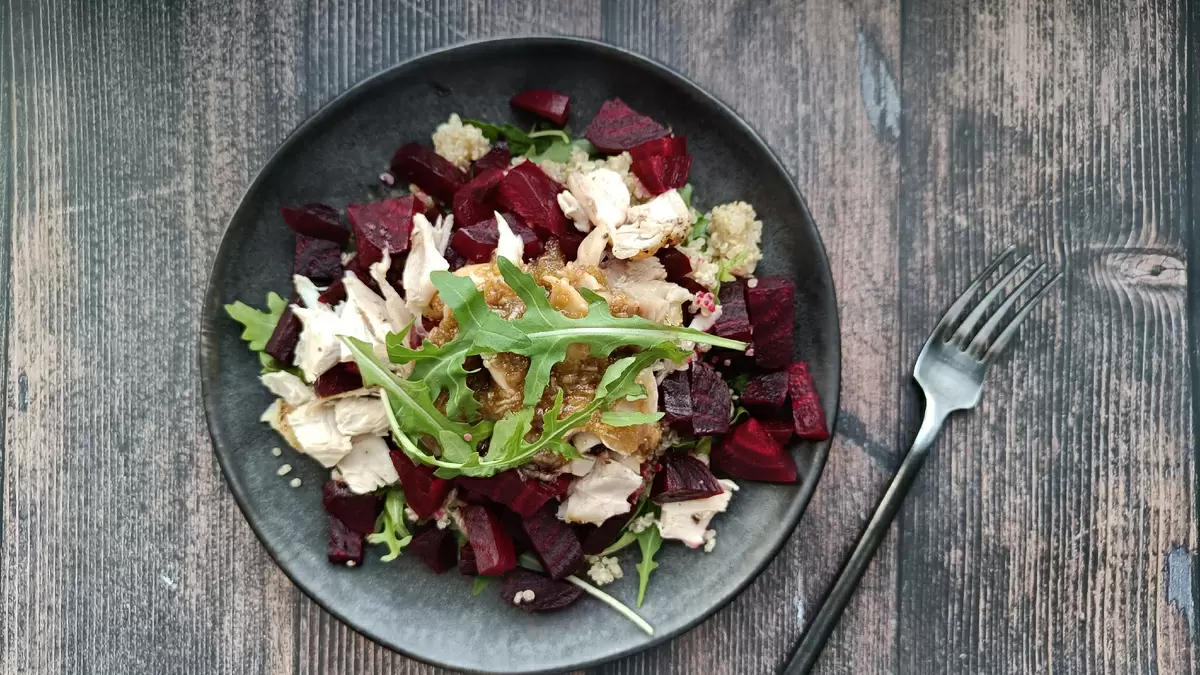 Салат с медовой заправкой. киноа, курица, свёкла и рукола в одной тарелке